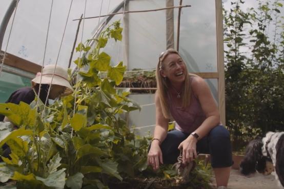 Lady in polytunnel growing vegetables